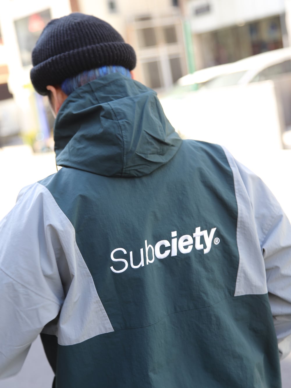 ブラック系のチノパンツ、グリーン系のナイロンジャケットを着用したメンズの冬コーディネートの2枚目の写真