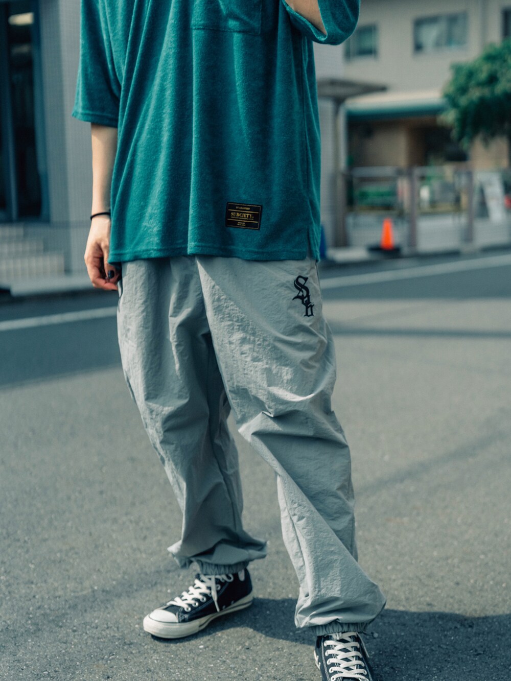 グリーン系のTシャツ/カットソー、グレー系のその他パンツを着用したメンズの夏コーディネートの2枚目の写真