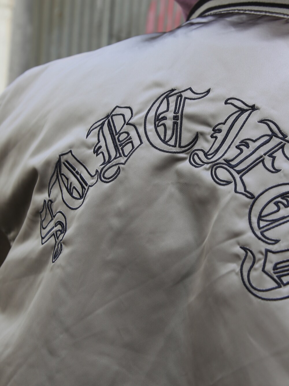 ブラック系のスラックス、グレー系のスタジャン、パープル系のパーカーを着用したメンズの秋コーディネートの4枚目の写真