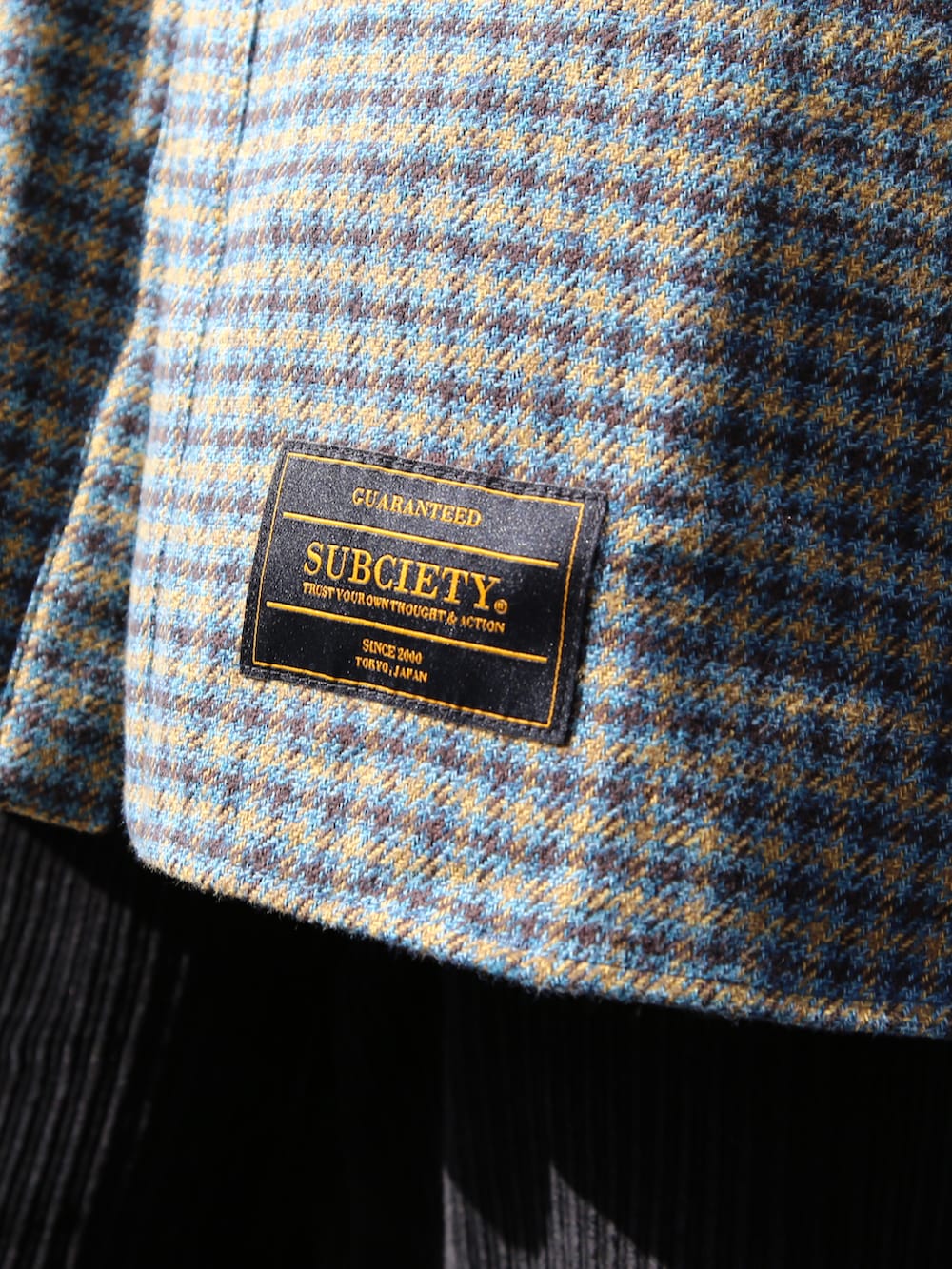 ブラック系のスラックス、ブルー系のシャツ/ブラウス、ブルー系のサングラスを着用したメンズの秋コーディネートの2枚目の写真