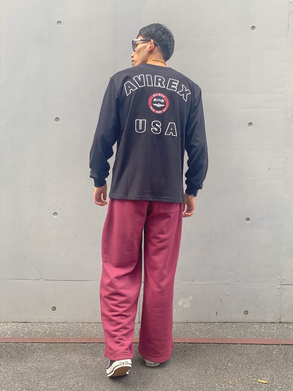 ブラック系のTシャツ/カットソー、ブラック系のTシャツ/カットソー、レッド系のスウェットパンツを着用したメンズの秋コーディネートの2枚目の写真