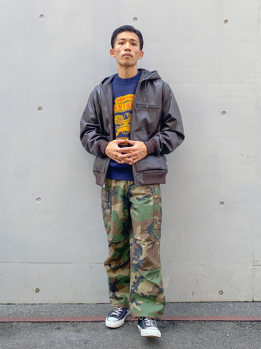 ブルー系のニット/セーター、ブラック系のTシャツ/カットソー、ブラウン系のブルゾンを着用したメンズの秋コーディネートの2枚目の写真