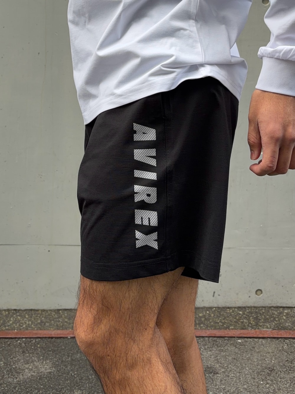 ホワイト系のTシャツ/カットソー、ブラック系のその他パンツ、ブラック系のキャップを着用したメンズの春コーディネートの4枚目の写真