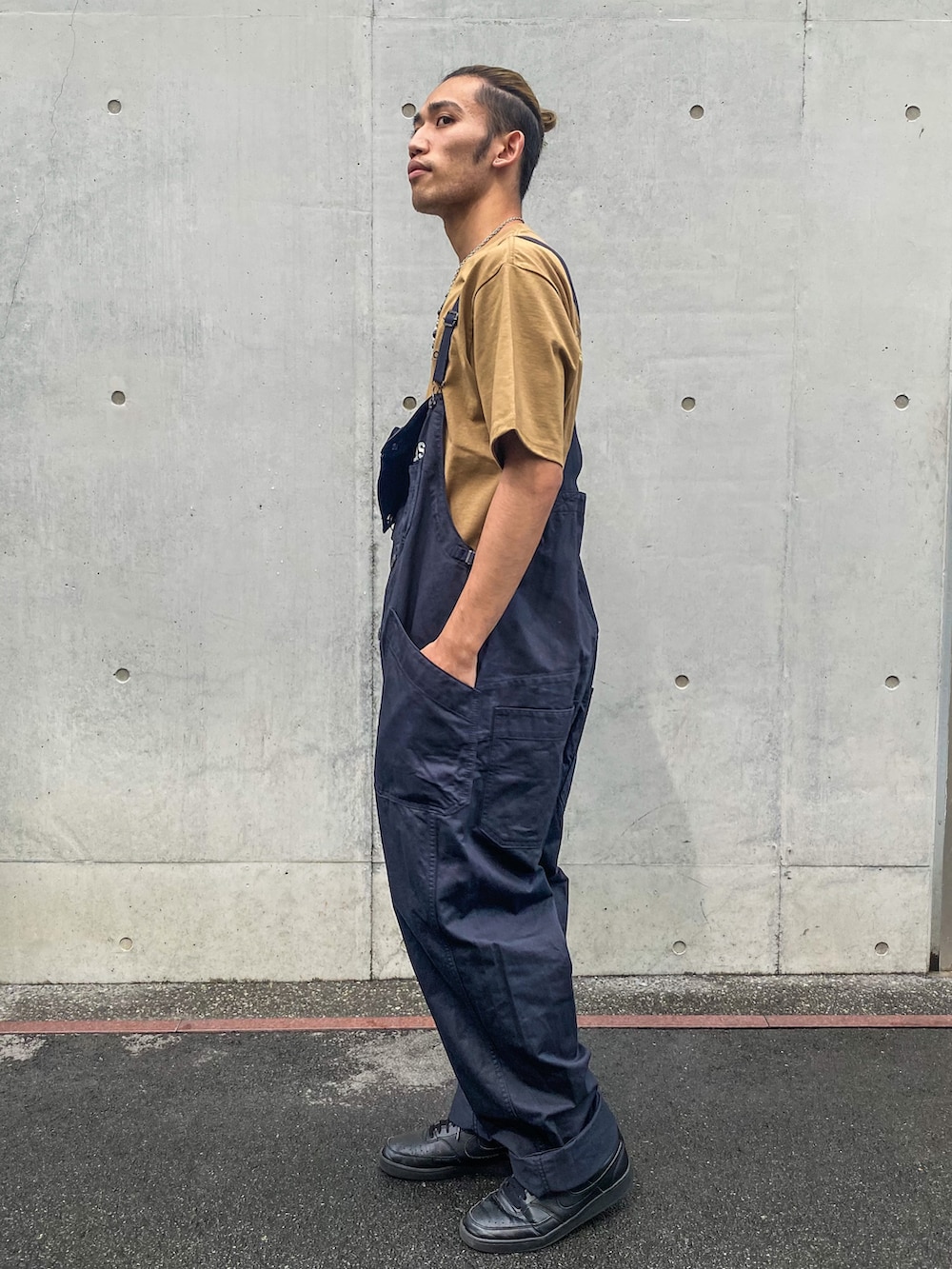 ブラック系のスニーカー、ブルー系のサロペット/オーバーオール、ブラウン系のTシャツ/カットソーを着用したメンズの夏コーディネートの3枚目の写真