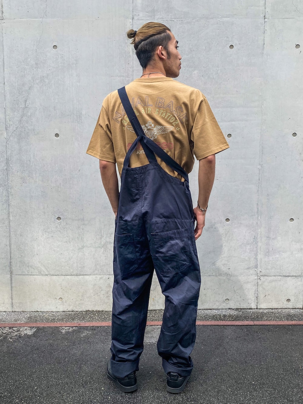 ブラック系のスニーカー、ブルー系のサロペット/オーバーオール、ブラウン系のTシャツ/カットソーを着用したメンズの夏コーディネートの4枚目の写真