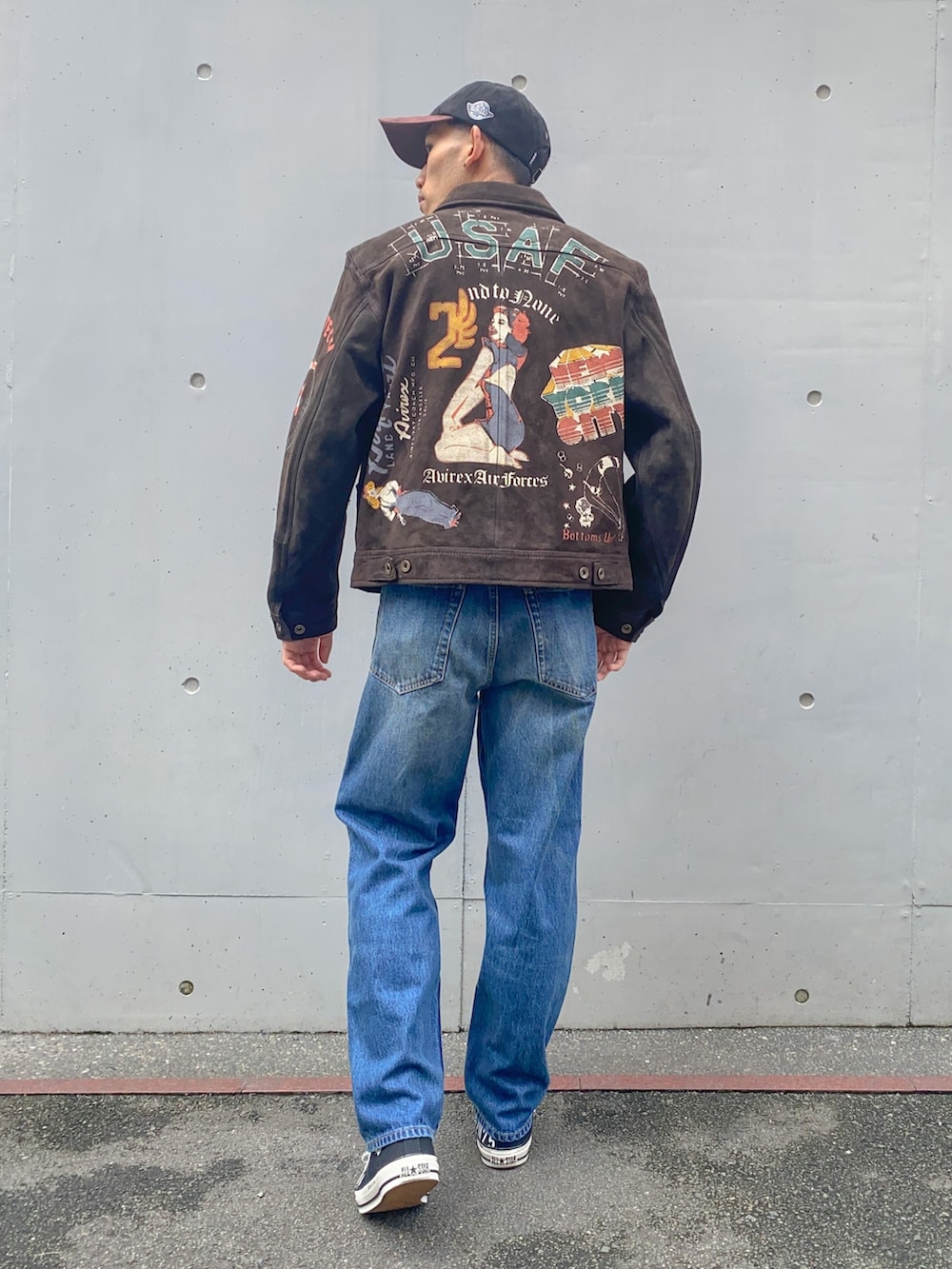 ベージュ系のTシャツ/カットソー、ブラウン系のブルゾン、ブルー系のデニムパンツを着用したメンズの秋コーディネートの2枚目の写真