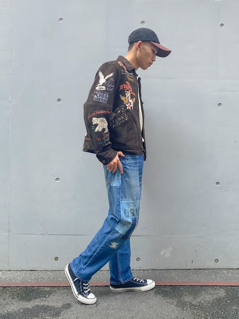 ベージュ系のTシャツ/カットソー、ブラウン系のブルゾン、ブルー系のデニムパンツを着用したメンズの秋コーディネートの3枚目の写真