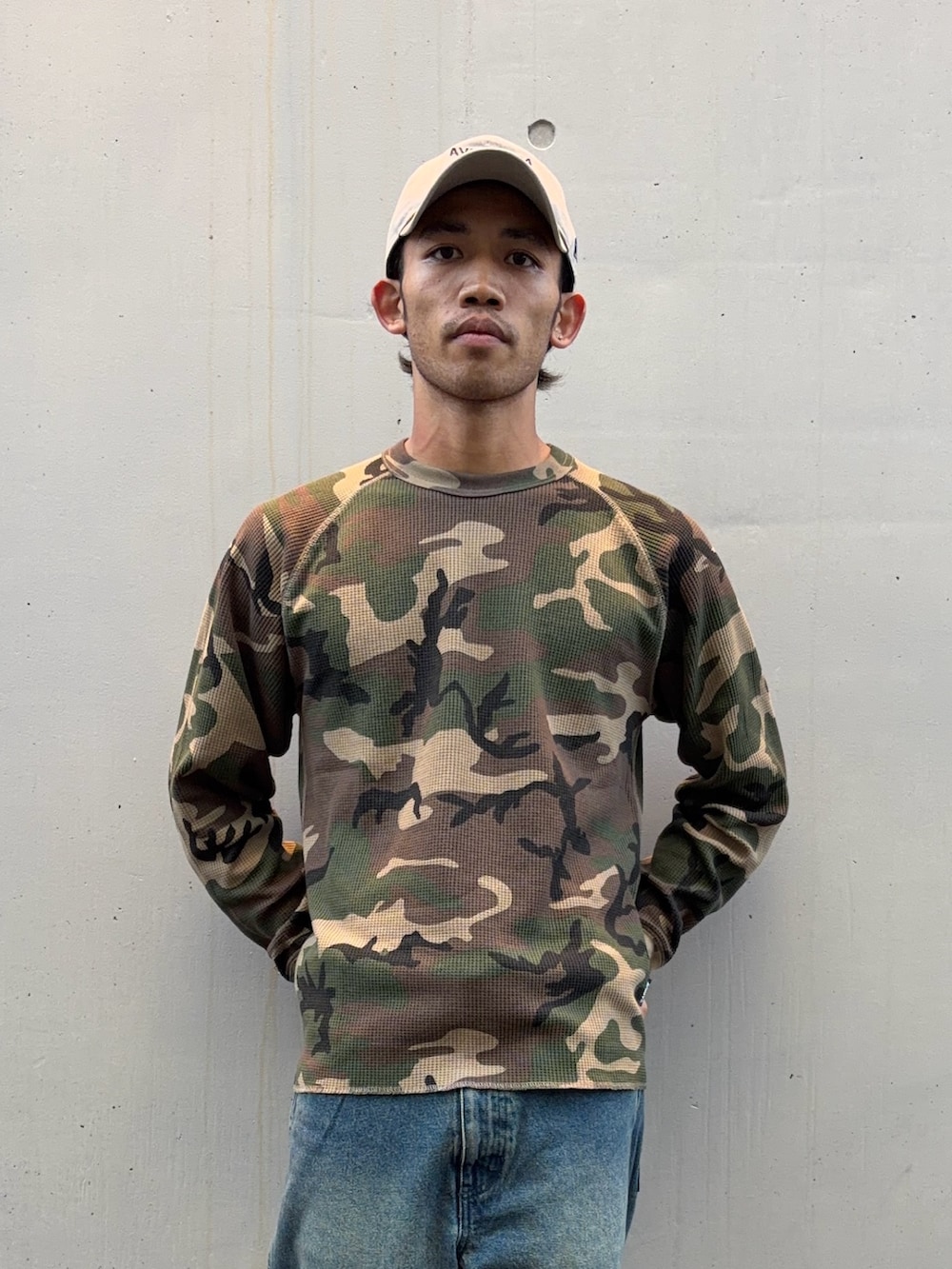 グリーン系のTシャツ/カットソー、ブラウン系のドレスシューズ、ベージュ系のキャップを着用したメンズの秋コーディネートの2枚目の写真