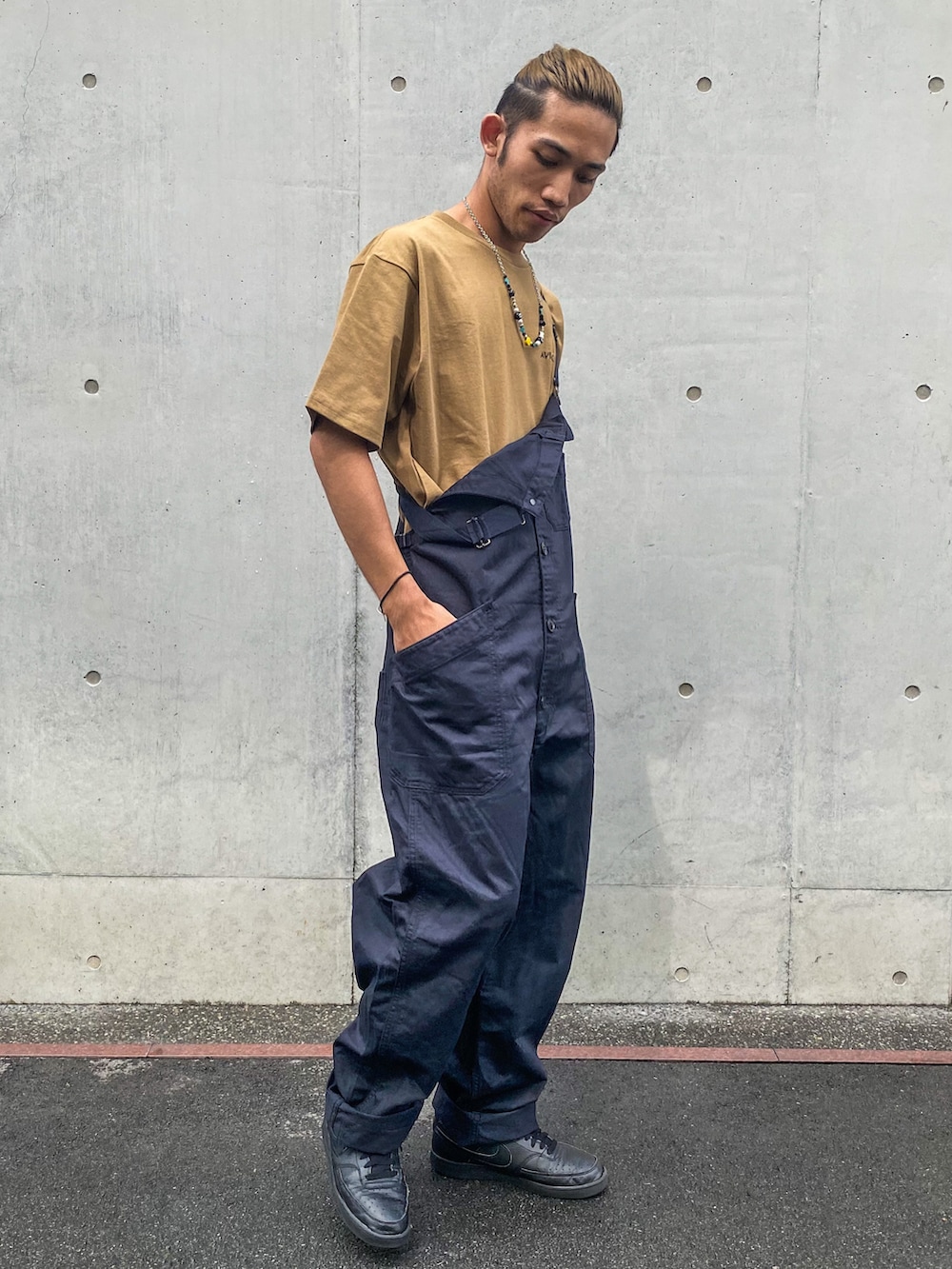 ブラック系のスニーカー、ブルー系のサロペット/オーバーオール、ブラウン系のTシャツ/カットソーを着用したメンズの夏コーディネートの2枚目の写真
