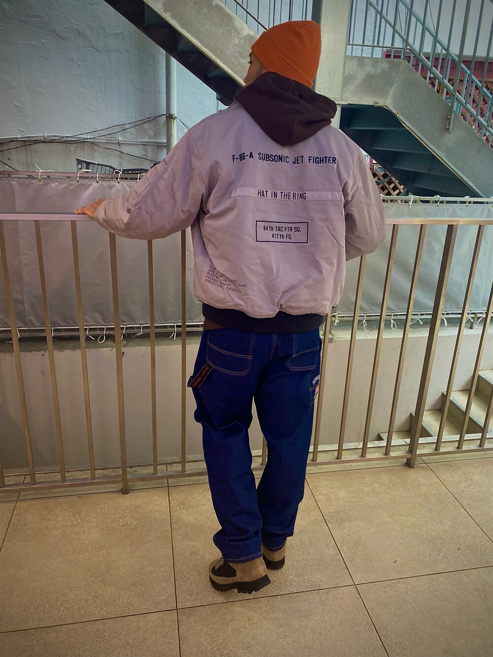 グレー系のMA-1、ブラウン系のパーカー、その他のデニムパンツを着用したメンズの冬コーディネートの2枚目の写真