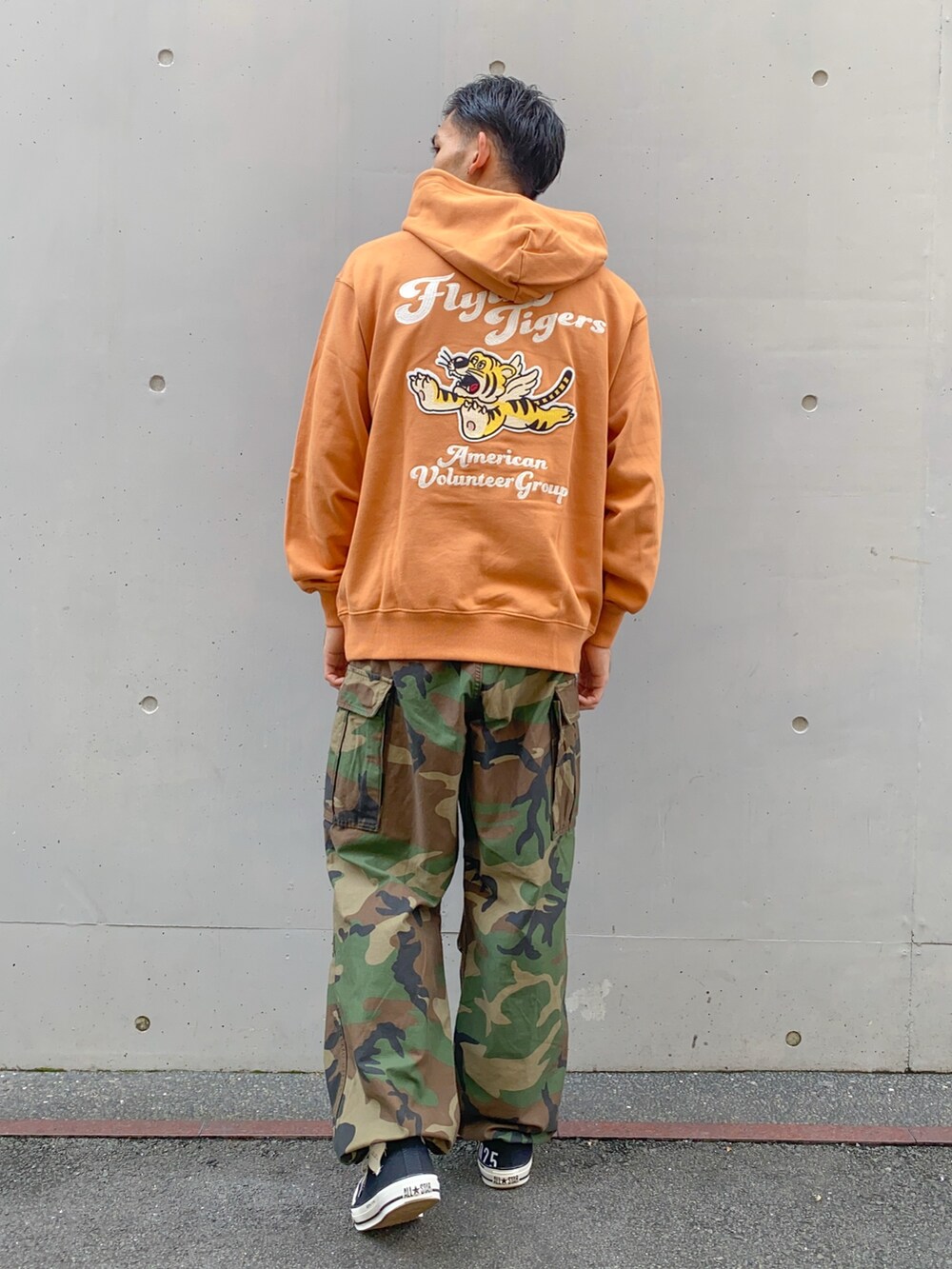 オレンジ系のパーカー、ブラック系のスニーカー、その他のカーゴパンツを着用したメンズの秋コーディネートの2枚目の写真