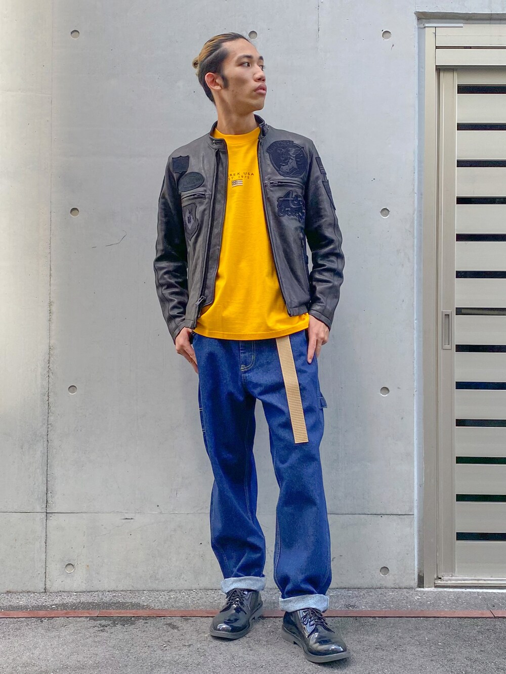 ブルー系のパンツ、ブラック系のドレスシューズ、ブラック系のライダースジャケットを着用したメンズの夏コーディネートの2枚目の写真