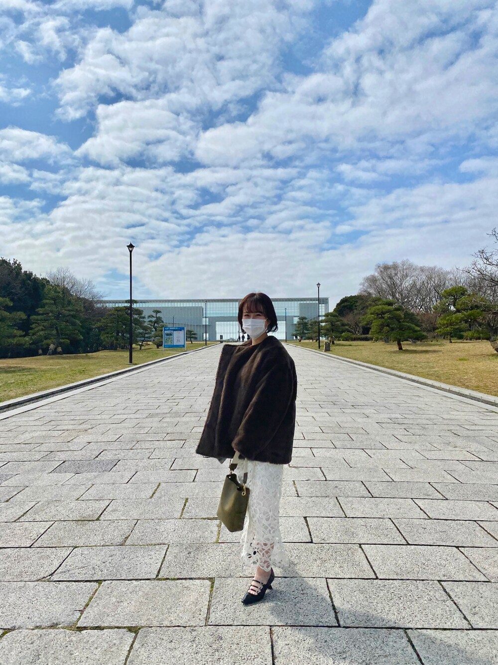 ホワイト系のスカート、ブラウン系のジャケット/アウター、グリーン系のハンドバッグを着用したレディースの春コーディネートの2枚目の写真