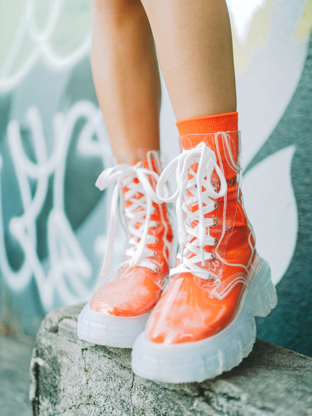 パープル系のパーカー、ベージュ系のスカート、その他のブーツを着用したレディースの秋コーディネートの2枚目の写真