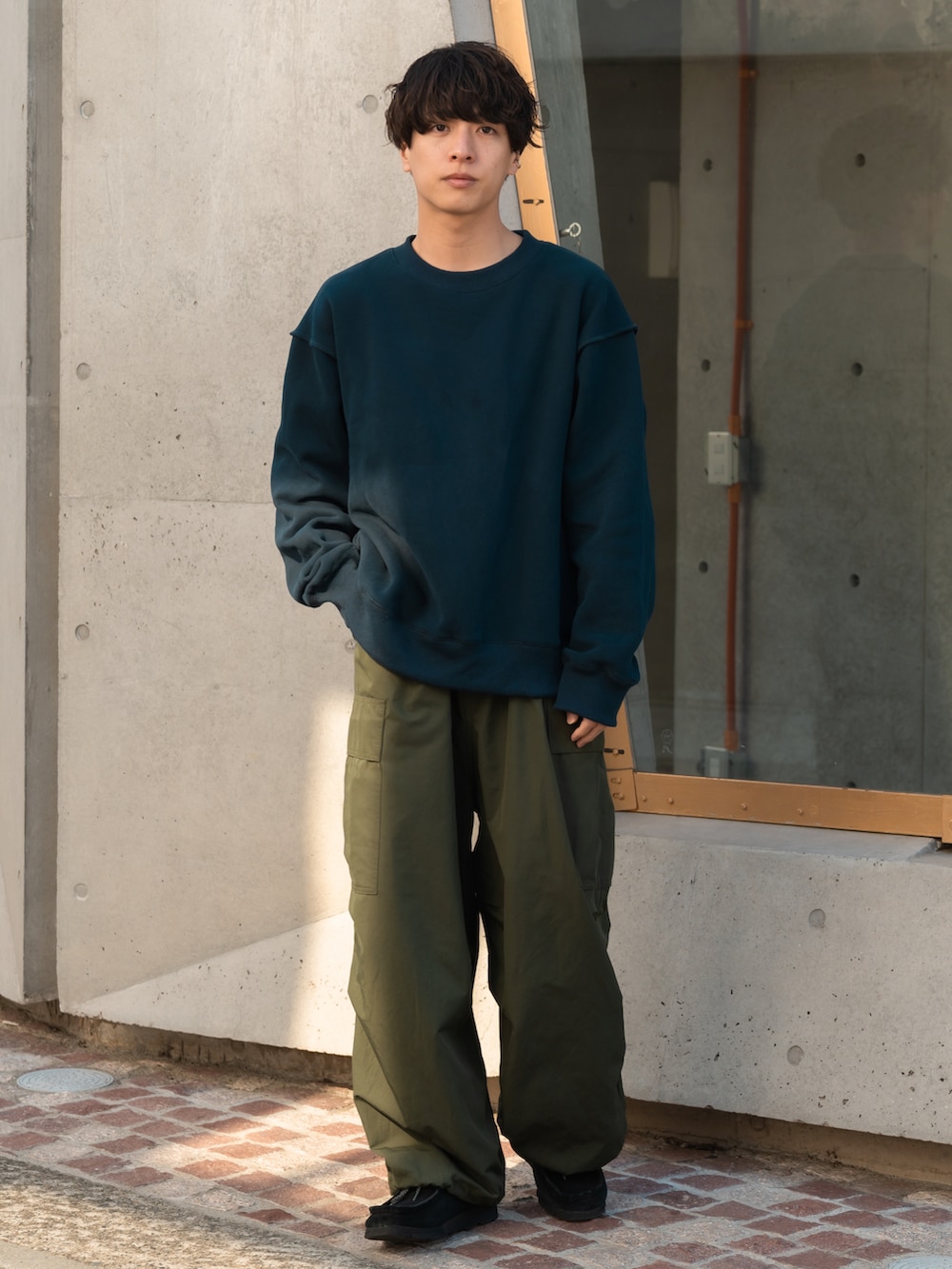 グリーン系のカーゴパンツ、ブラック系のモカシン/デッキシューズを着用したメンズの春コーディネートの2枚目の写真