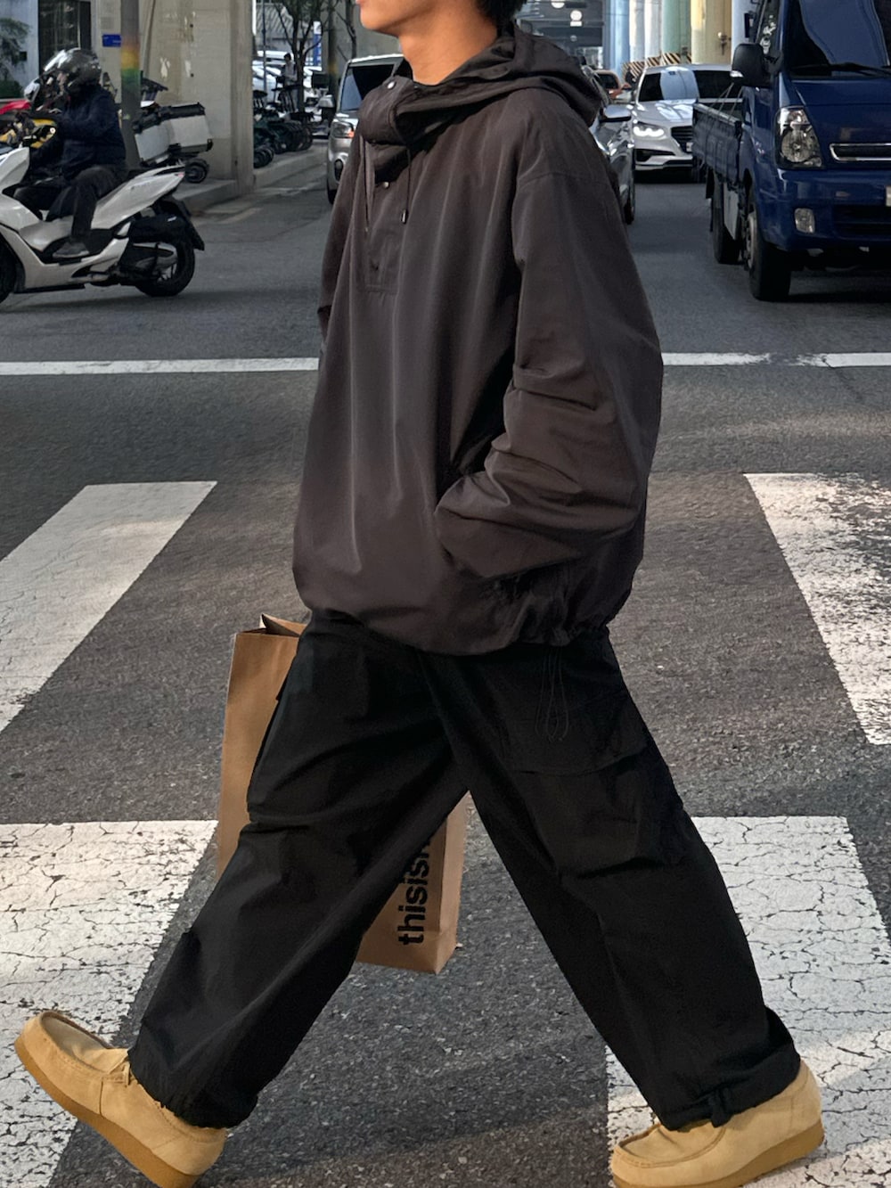 グレー系のパーカー、ブラック系のカーゴパンツ、ベージュ系のモカシン/デッキシューズを着用したメンズの秋コーディネートの3枚目の写真