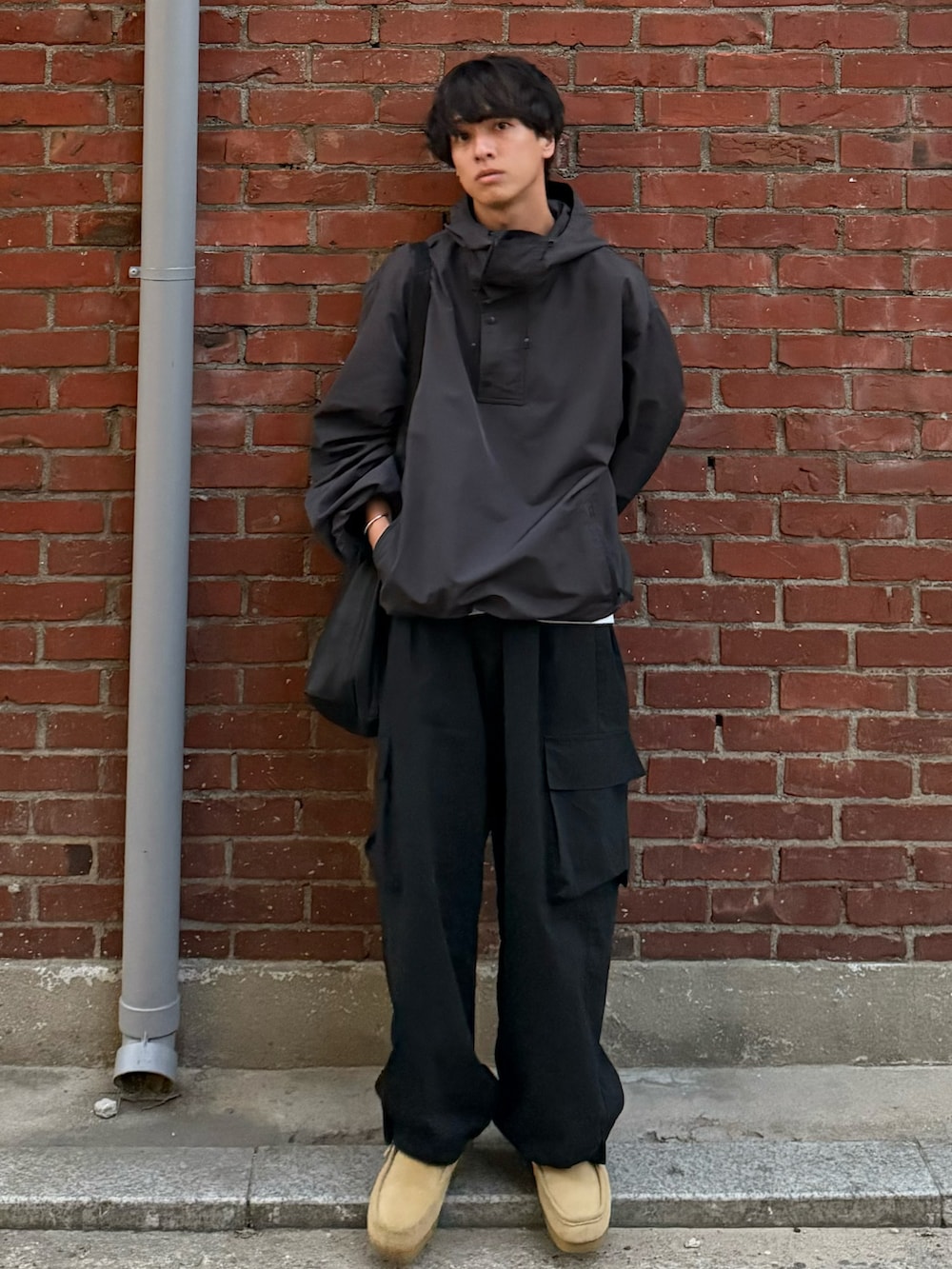 グレー系のパーカー、ブラック系のカーゴパンツ、ベージュ系のモカシン/デッキシューズを着用したメンズの秋コーディネートの2枚目の写真