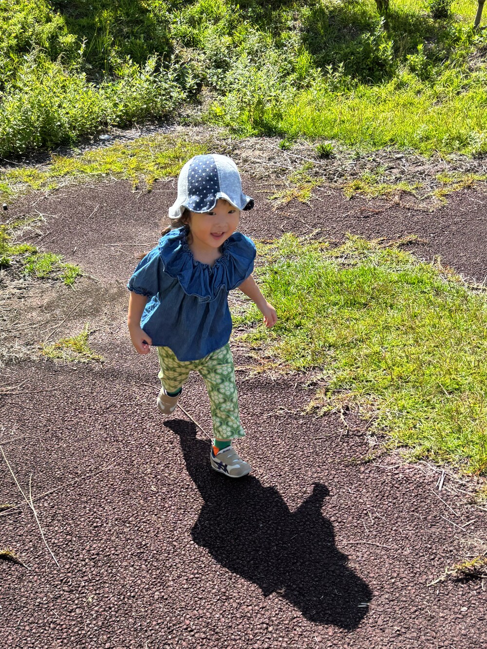 グリーン系のトップスを着用したキッズの秋コーディネートの2枚目の写真