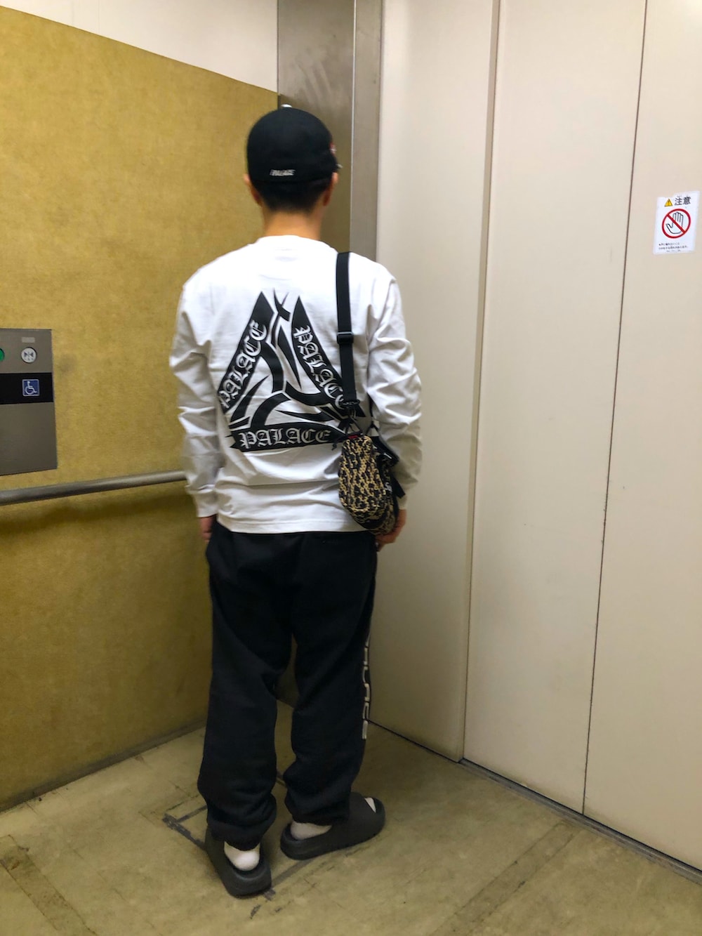 ブラック系のサンダル、ブラック系のスウェットパンツ、ホワイト系のTシャツ/カットソーを着用したメンズの春コーディネートの2枚目の写真