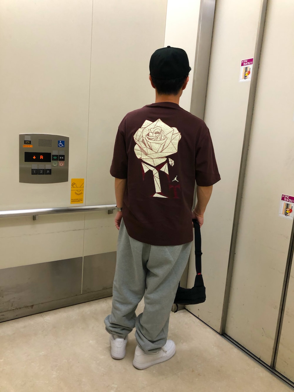 ホワイト系のスニーカー、グレー系のスウェットパンツ、ブラウン系のTシャツ/カットソーを着用したメンズの春コーディネートの2枚目の写真