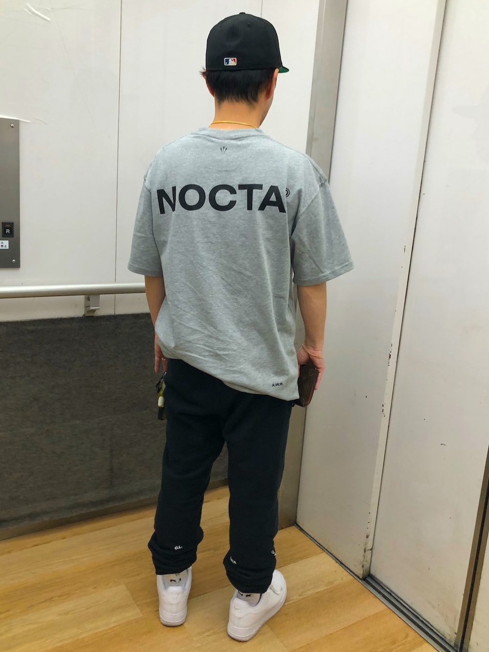 グレー系のTシャツ/カットソー、ブラック系のスウェットパンツ、ホワイト系のスニーカーを着用したメンズの春コーディネートの2枚目の写真
