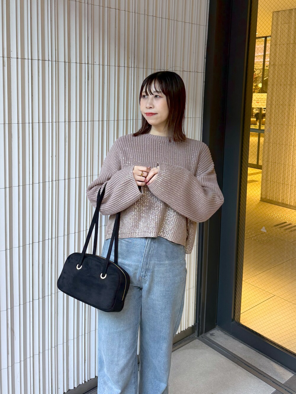 ブラウン系のニット/セーターを着用したレディースの冬コーディネートの2枚目の写真