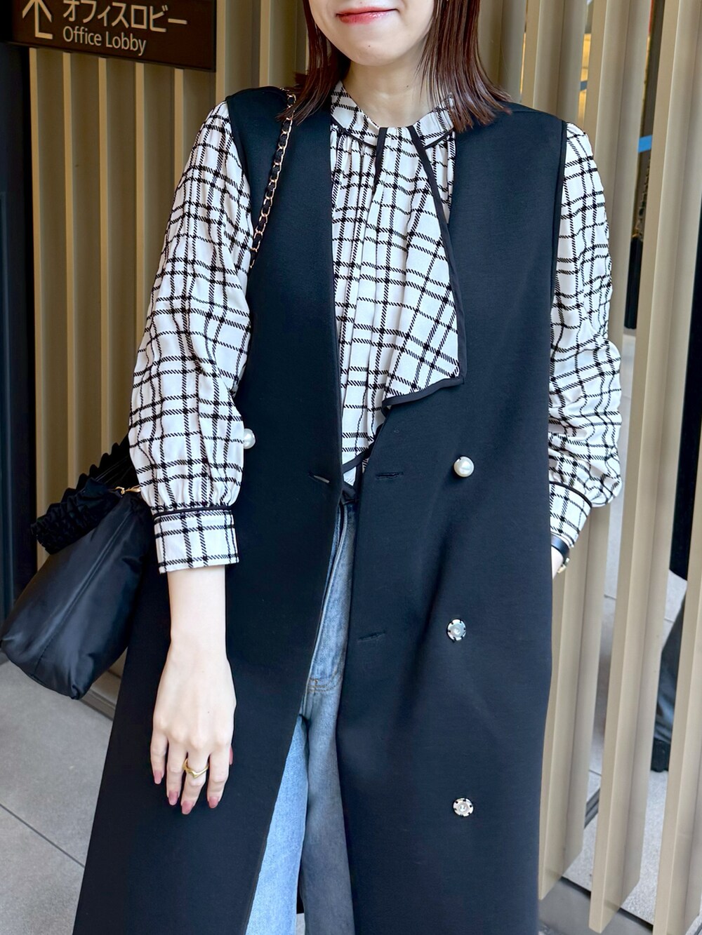 ホワイト系のシャツ/ブラウス、ブラック系のその他アウター、ブラック系のショルダーバッグを着用したレディースの冬コーディネートの4枚目の写真