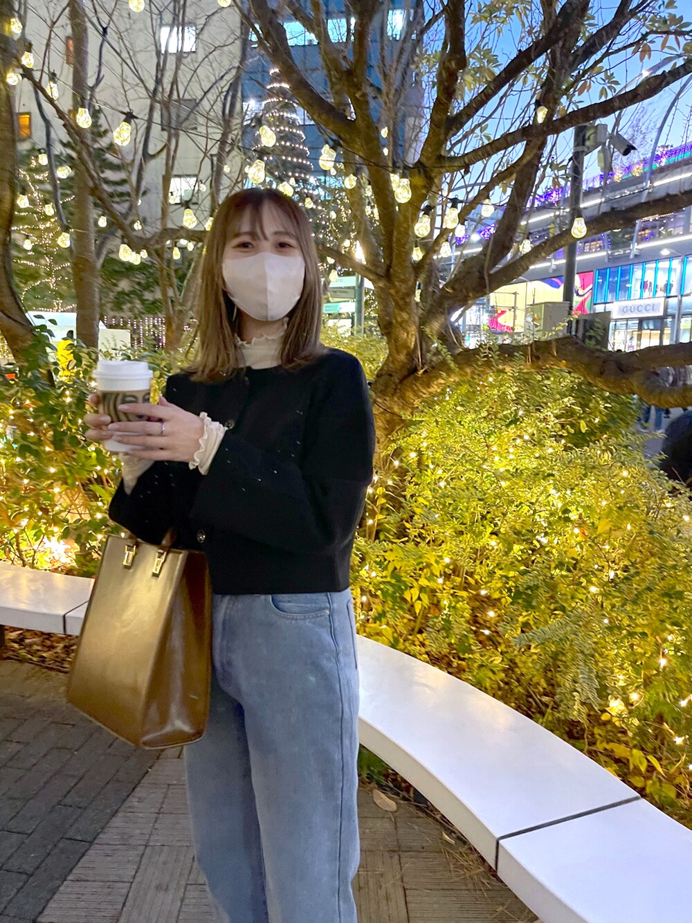 ブラック系のノーカラージャケット、ブルー系のデニムパンツを着用したレディースの冬コーディネートの2枚目の写真
