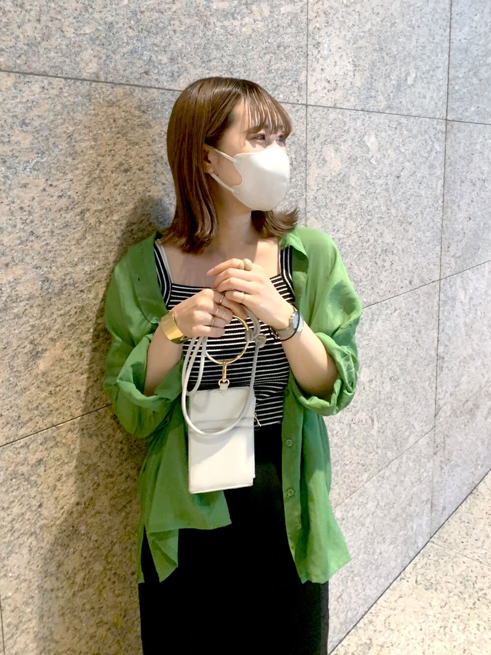 グリーン系のシャツ/ブラウス、ブラック系のキャミソール、ホワイト系のショルダーバッグを着用したレディースの夏コーディネートの2枚目の写真