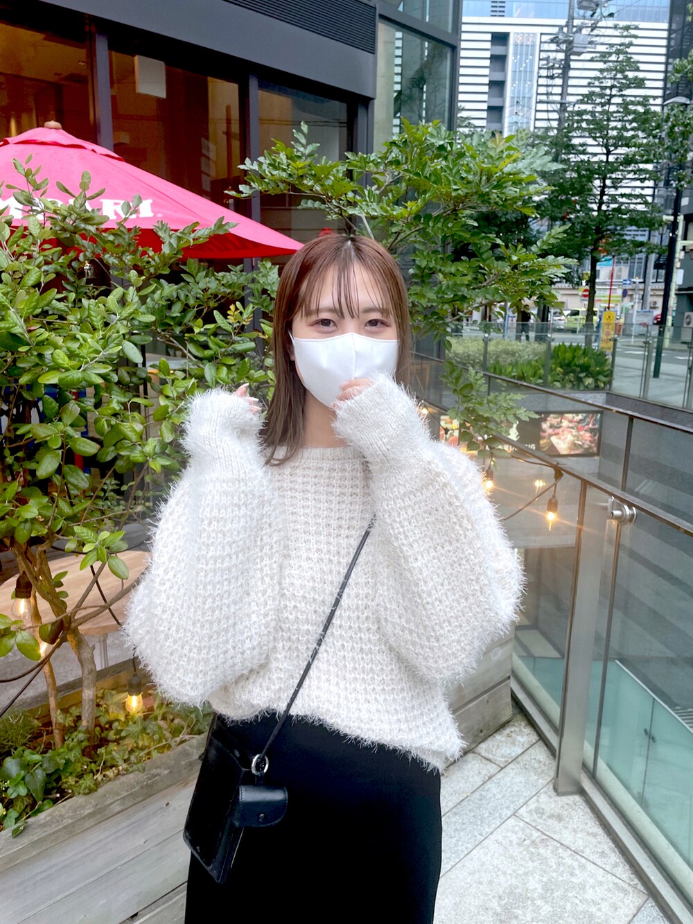 ホワイト系のニット/セーター、ブラック系のスカートを着用したレディースの冬コーディネートの2枚目の写真