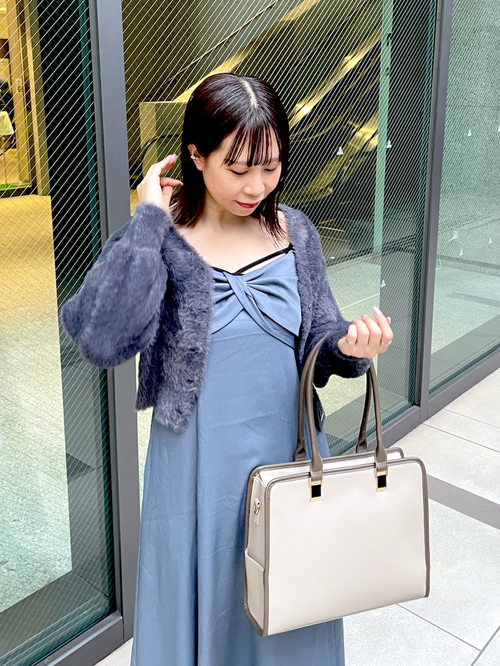 ブルー系のワンピース、グレー系のカーディガン/ボレロ、ベージュ系のショルダーバッグを着用したレディースの秋コーディネートの2枚目の写真