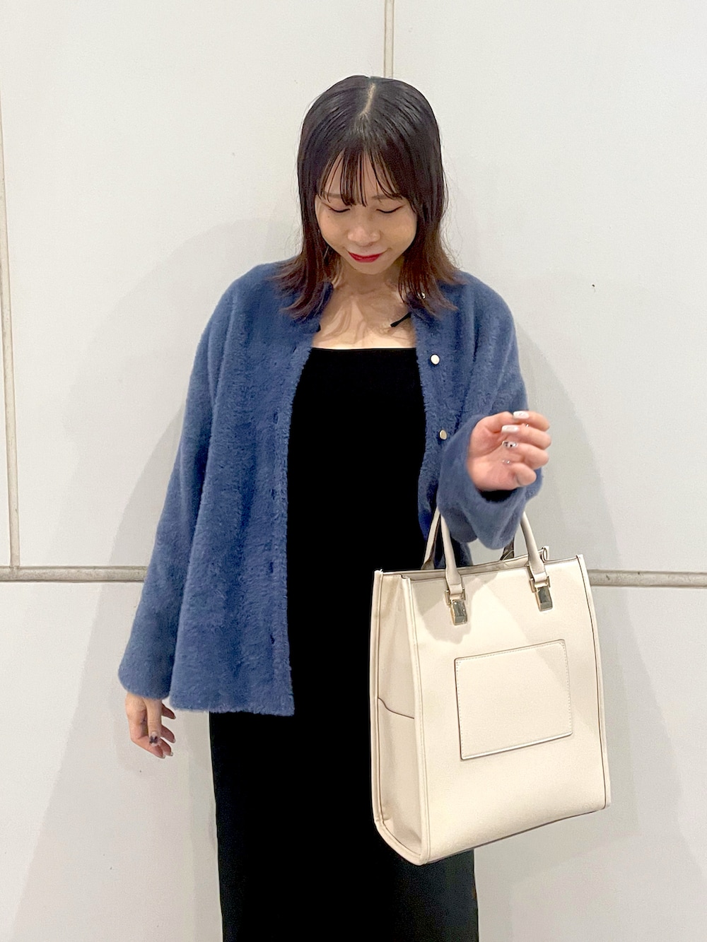 ブルー系のカーディガン/ボレロ、ホワイト系のショルダーバッグを着用したレディースの秋コーディネートの2枚目の写真