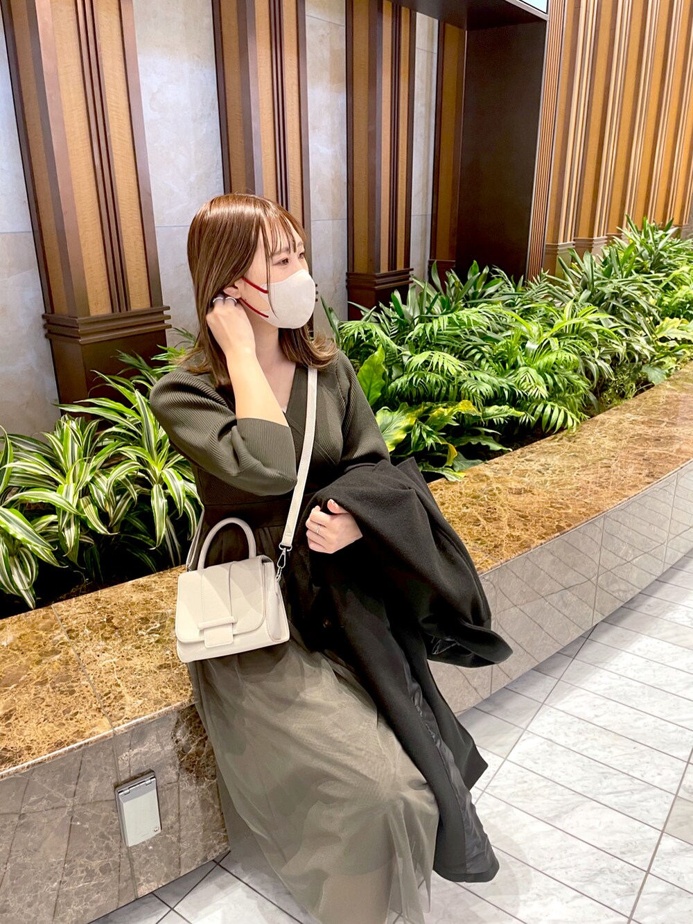 グリーン系のワンピースを着用したレディースの冬コーディネートの2枚目の写真