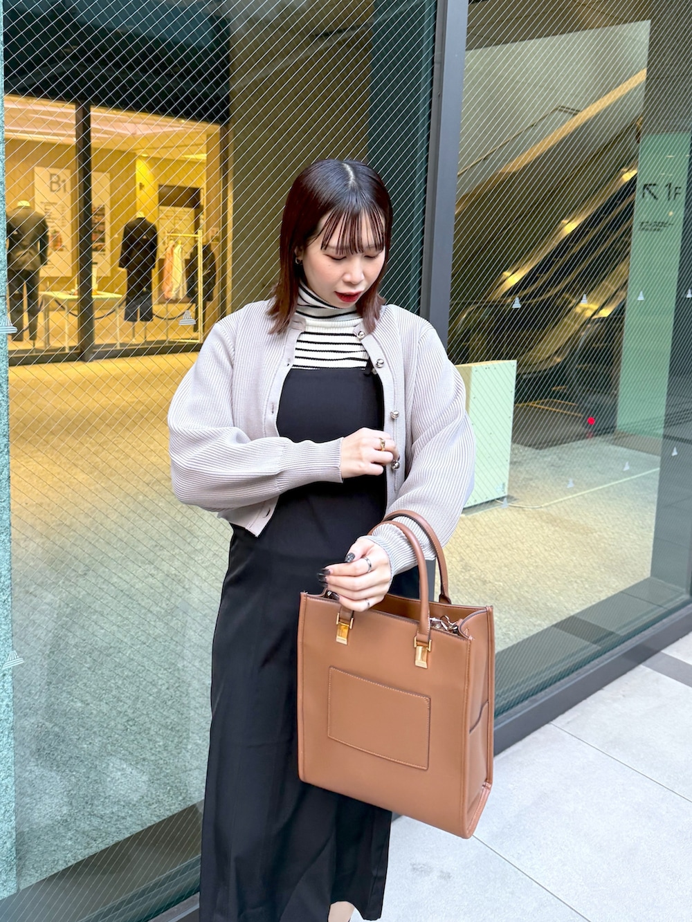 ベージュ系のカーディガン/ボレロを着用したレディースの冬コーディネートの2枚目の写真