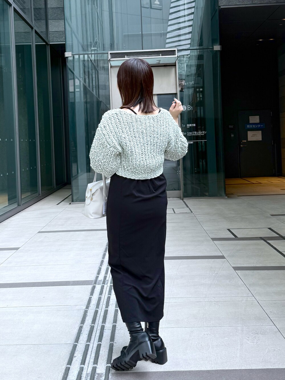 ブラック系のワンピース、グリーン系のカーディガン/ボレロを着用したレディースの春コーディネートの3枚目の写真