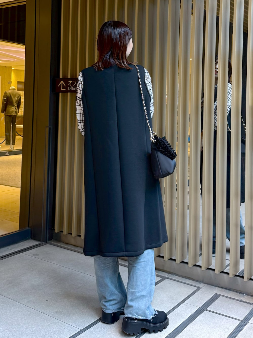 ホワイト系のシャツ/ブラウス、ブラック系のその他アウター、ブラック系のショルダーバッグを着用したレディースの冬コーディネートの3枚目の写真