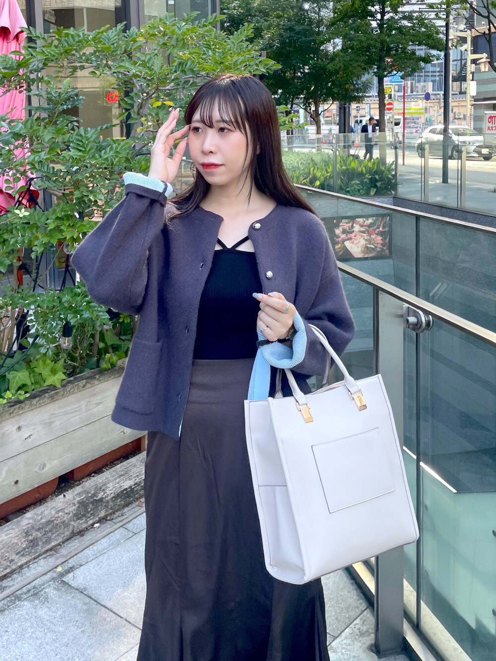 グレー系のノーカラージャケット、ブラウン系のスカート、ブラック系のパンプスを着用したレディースの秋コーディネートの3枚目の写真