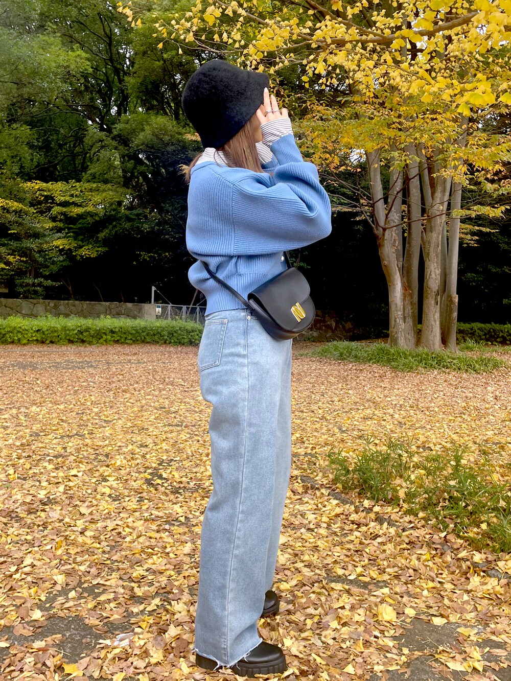 ブルー系のカーディガン/ボレロ、ブルー系のデニムパンツ、ブラック系のハットを着用したレディースの冬コーディネートの2枚目の写真