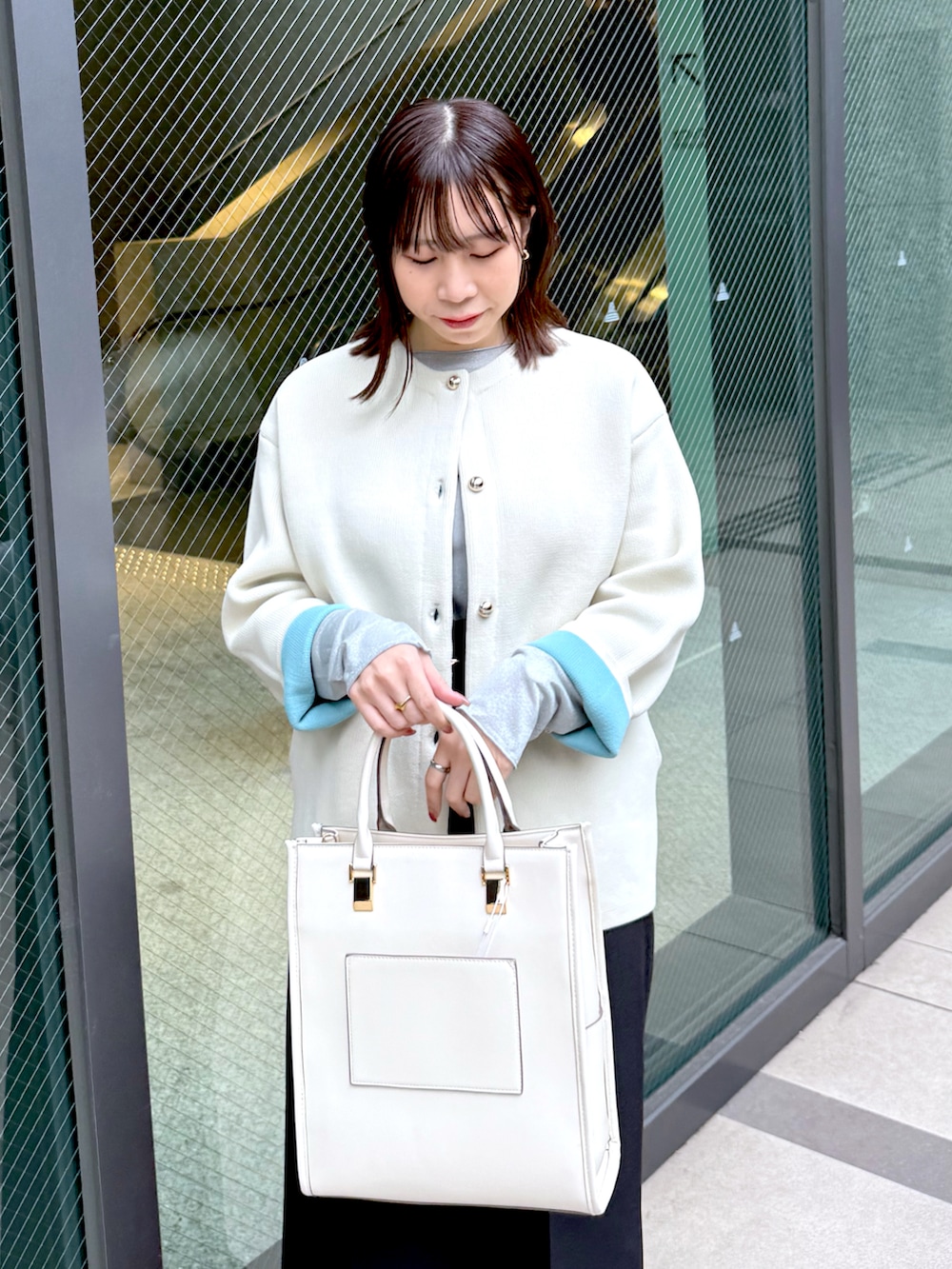 ベージュ系のカーディガン/ボレロ、ブラック系のその他パンツ、ホワイト系のショルダーバッグを着用したレディースの冬コーディネートの2枚目の写真