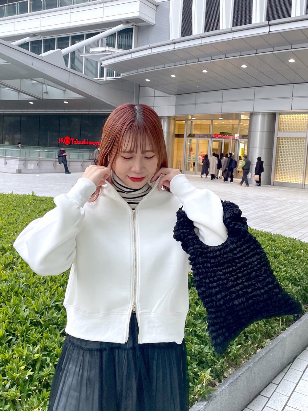 ブラック系のスニーカー、ブラック系のワンピース、ブルー系のデニムパンツを着用したレディースの冬コーディネートの2枚目の写真