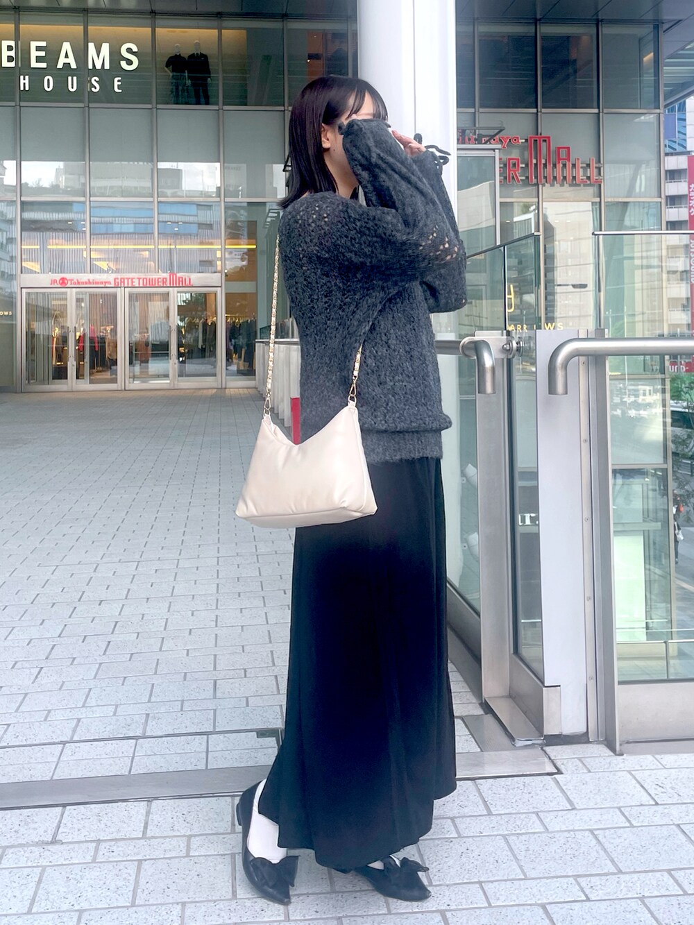 グレー系のワンピース、ホワイト系のショルダーバッグを着用したレディースの秋コーディネートの2枚目の写真