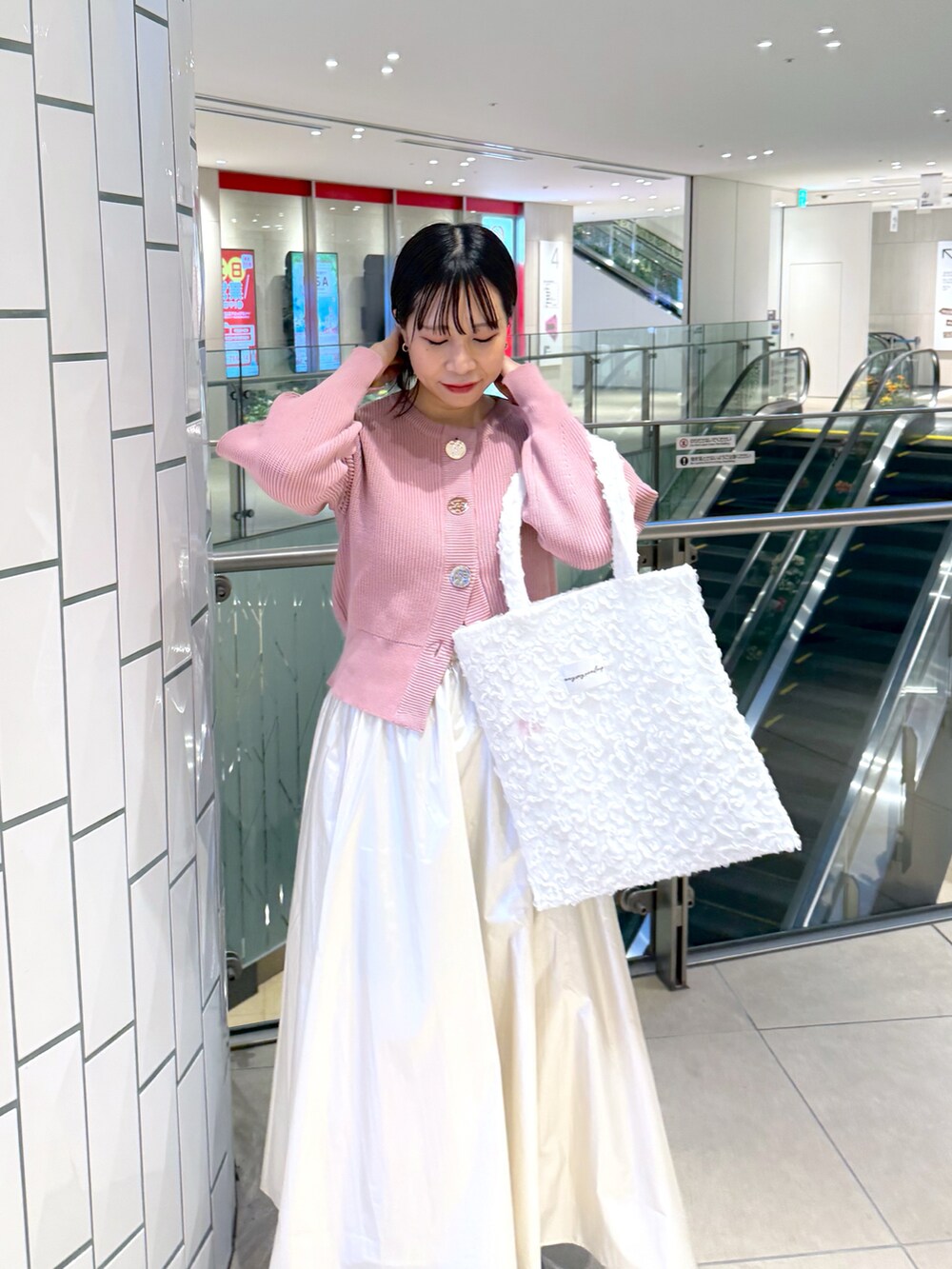 ピンク系のカーディガン/ボレロ、ホワイト系のスカートを着用したレディースの冬コーディネートの2枚目の写真