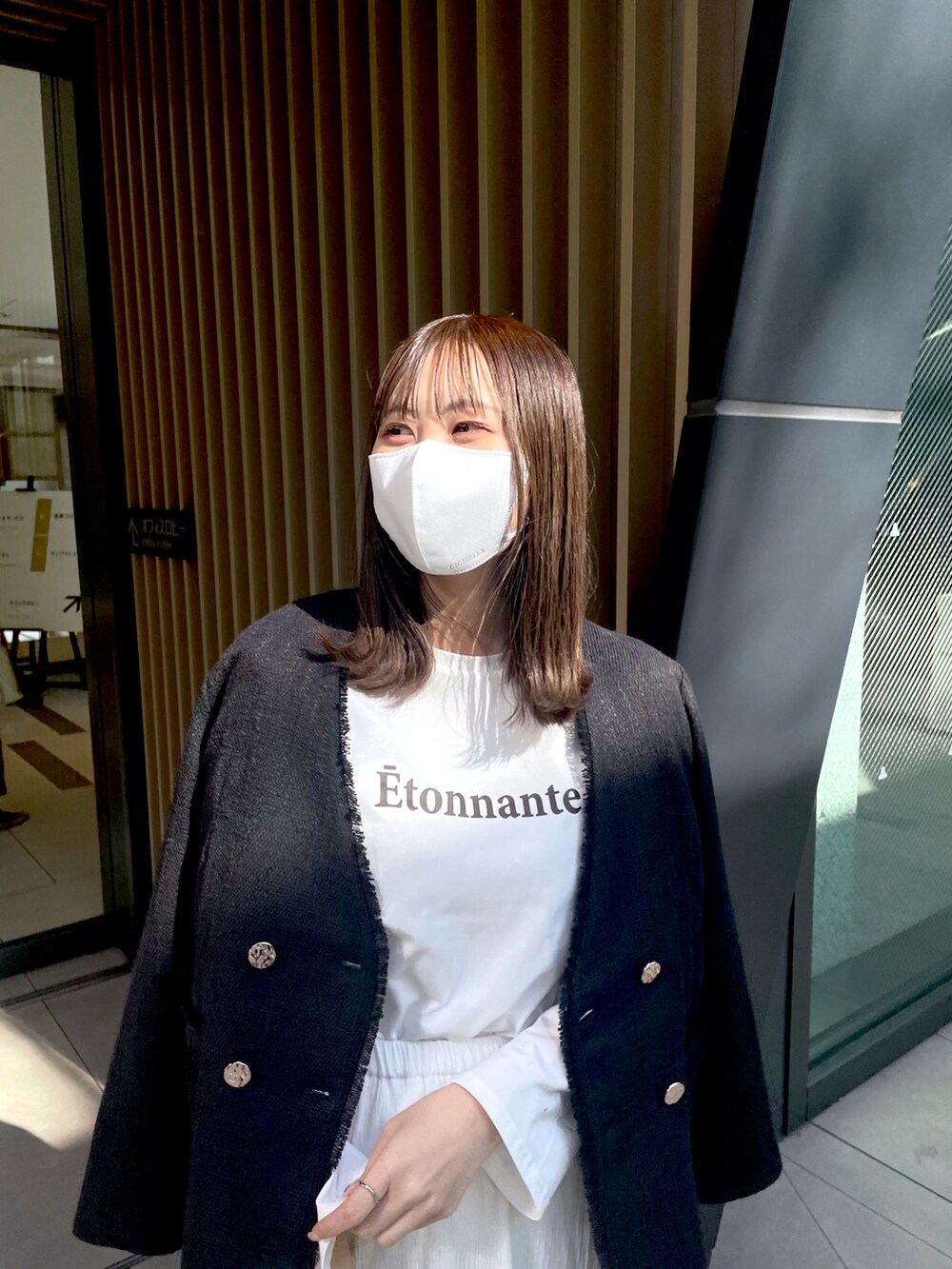 ホワイト系のスカート、ブラック系のノーカラージャケットを着用したレディースの冬コーディネートの2枚目の写真