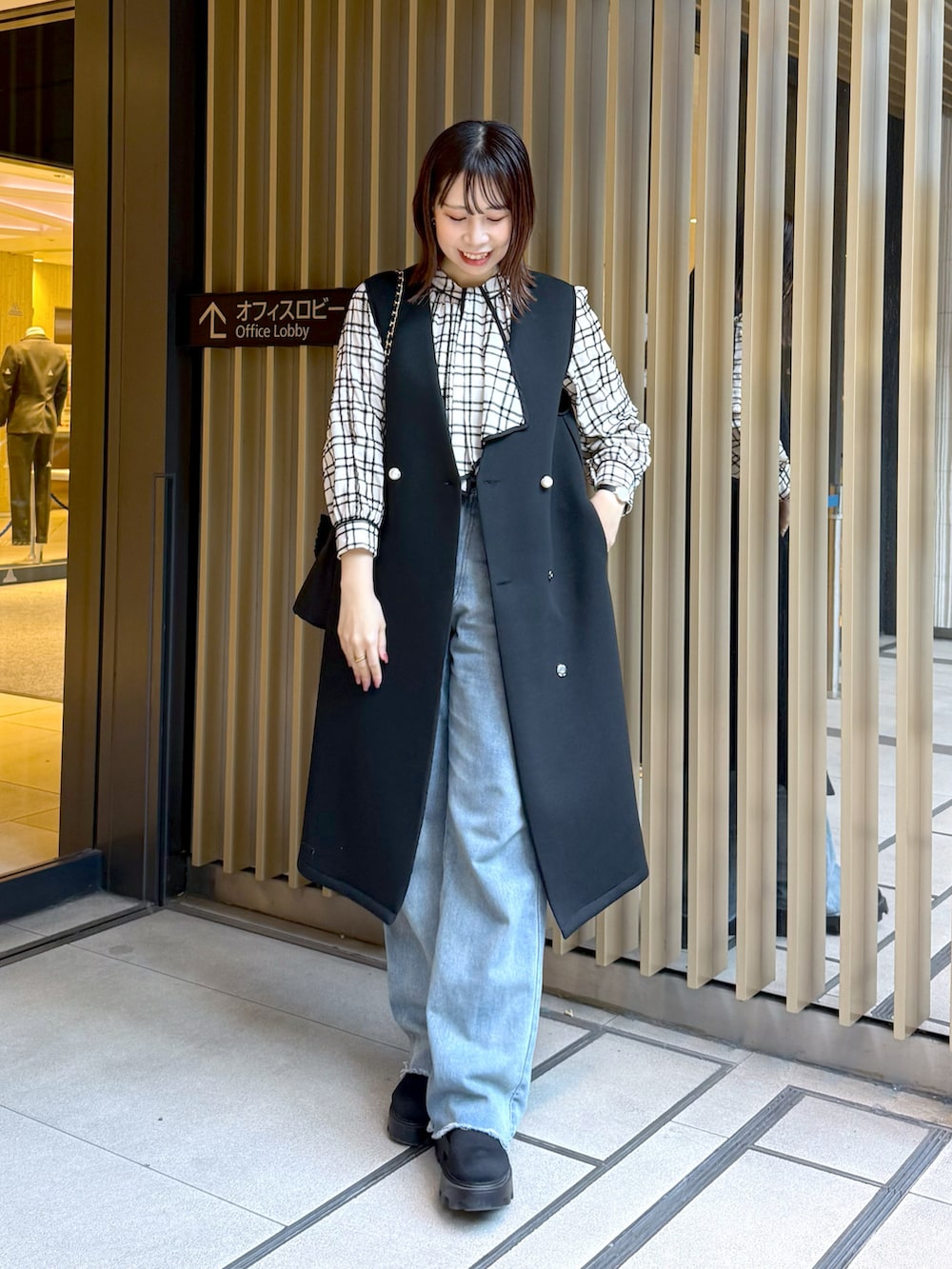 ホワイト系のシャツ/ブラウス、ブラック系のその他アウター、ブラック系のショルダーバッグを着用したレディースの冬コーディネートの2枚目の写真