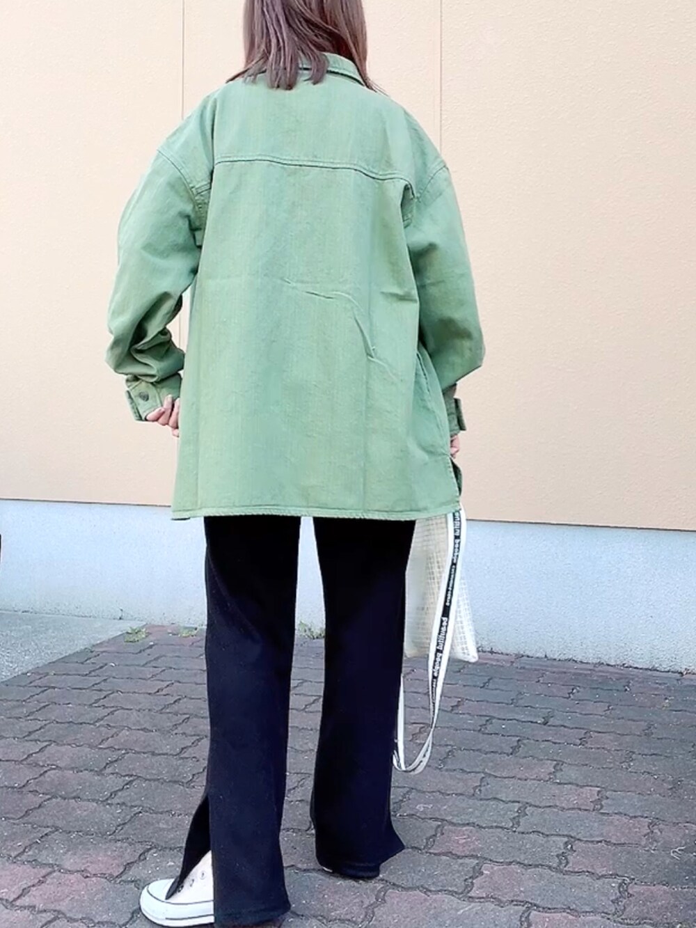 グリーン系のデニムジャケット、ホワイト系のTシャツ/カットソー、ホワイト系のショルダーバッグを着用したレディースの春コーディネートの3枚目の写真