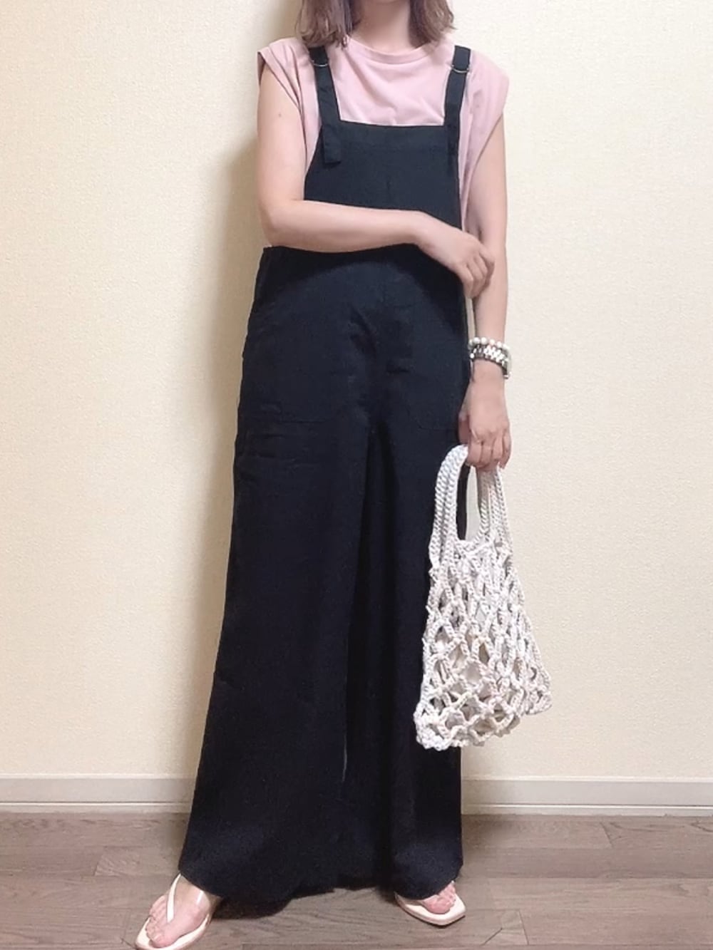 ピンク系のTシャツ/カットソー、ブラック系のサロペット/オーバーオール、ホワイト系のハンドバッグを着用したレディースの夏コーディネートの2枚目の写真