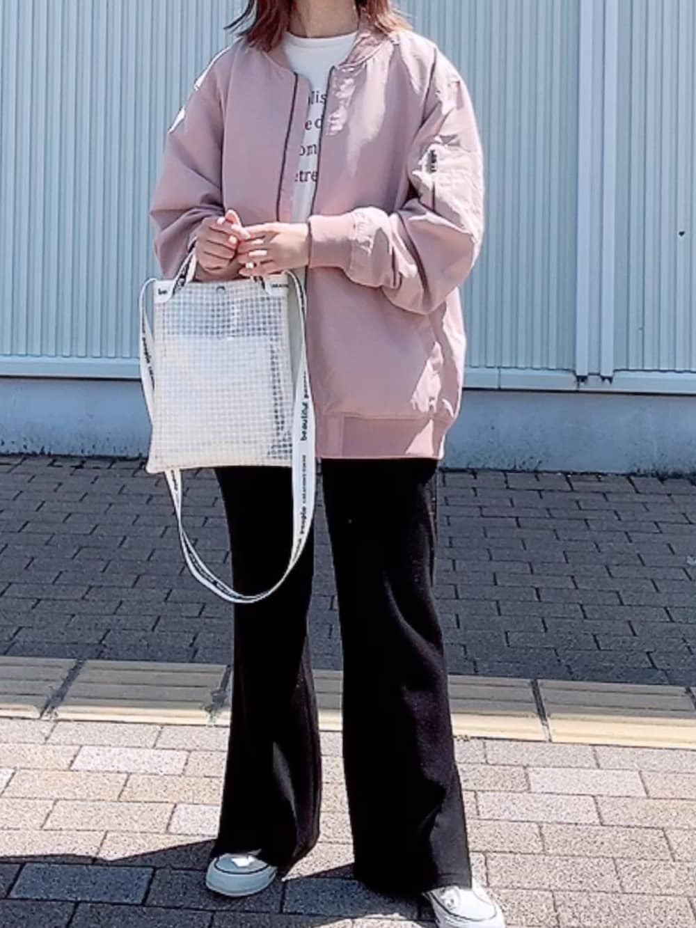 ピンク系のMA-1、ホワイト系のTシャツ/カットソー、ホワイト系のショルダーバッグを着用したレディースの春コーディネートの2枚目の写真