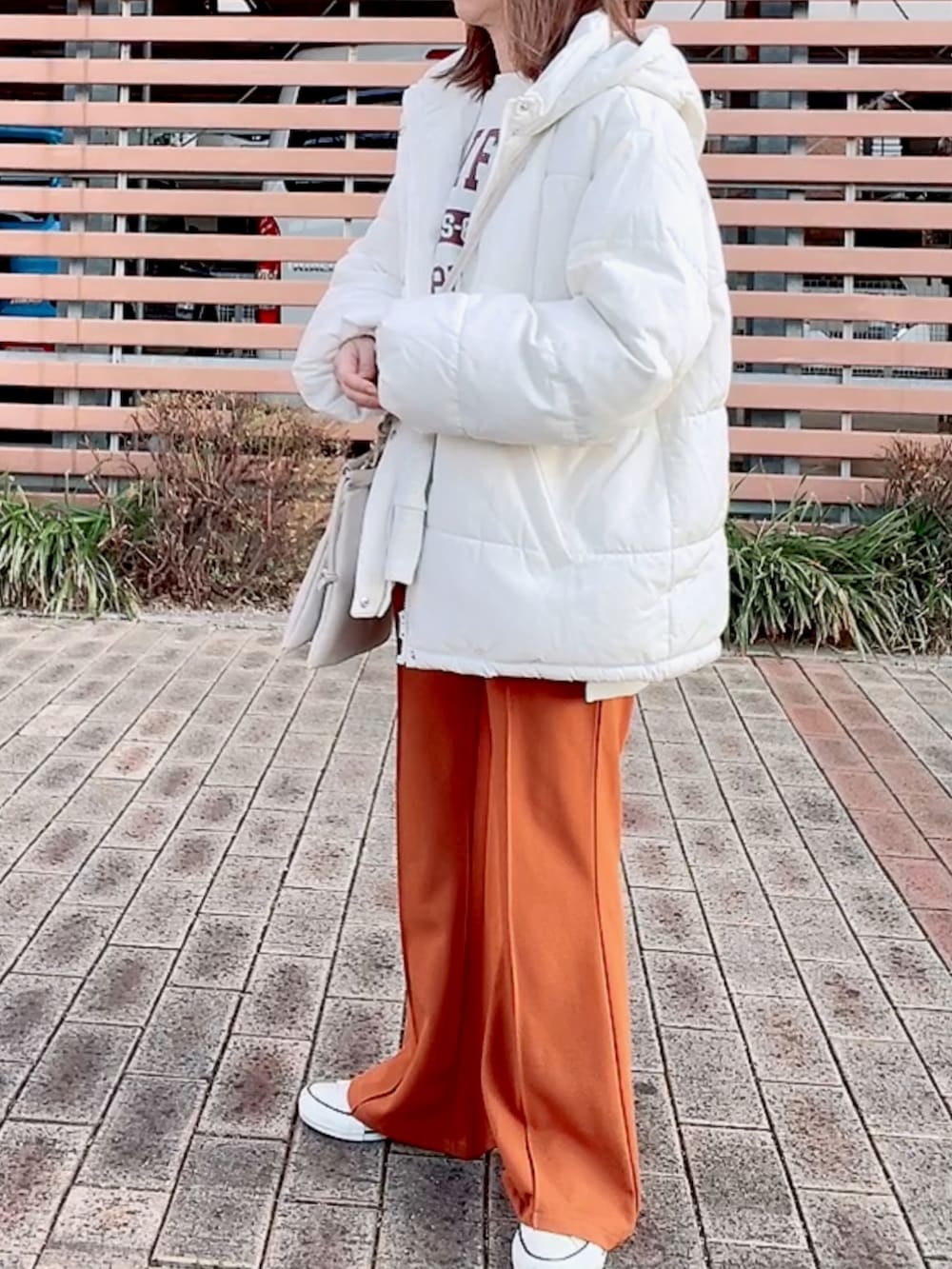 ホワイト系のダウンジャケット/コート、ベージュ系のスウェット、ホワイト系のショルダーバッグを着用したレディースの冬コーディネートの3枚目の写真