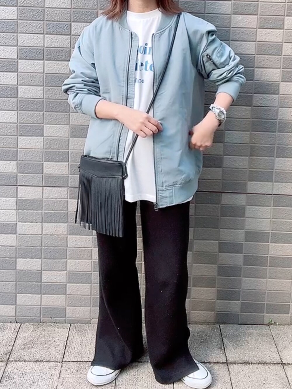 ブルー系のMA-1、ホワイト系のTシャツ/カットソー、ブラック系のショルダーバッグを着用したレディースの春コーディネートの2枚目の写真