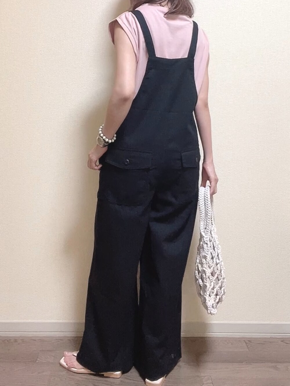 ピンク系のTシャツ/カットソー、ブラック系のサロペット/オーバーオール、ホワイト系のハンドバッグを着用したレディースの夏コーディネートの4枚目の写真